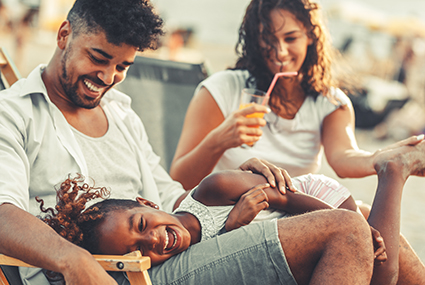 Young,mixed,race,family,sitting,and,relaxing,at,the,beach