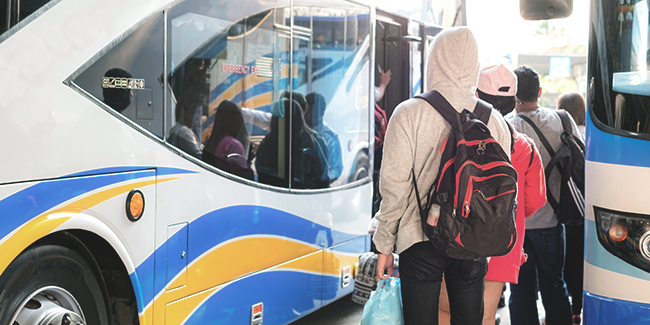 Man with backpack waiting to board a bus
