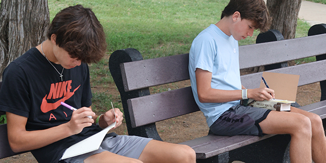 Young men studying their Bible at camp