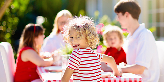 Family eating dinner outdoors in summertime