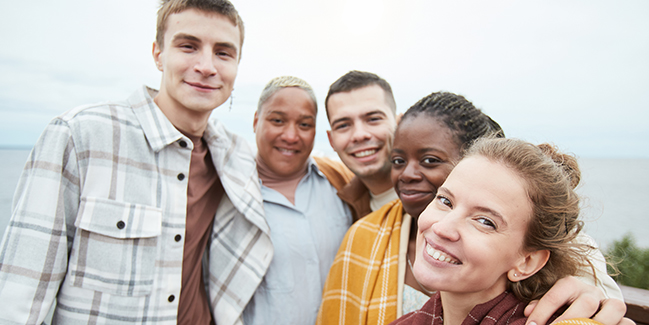 Teens smile for a photo with their adult mentors