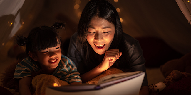Parent and son reading a book at bedtime