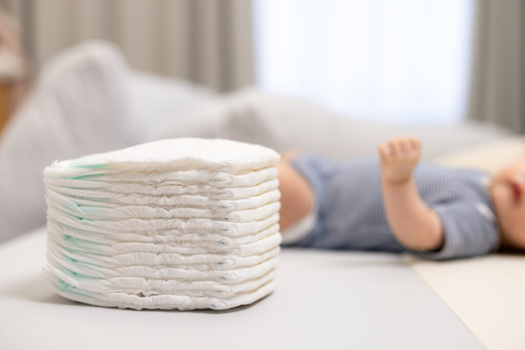 Newborn Baby Resting Peacefully With Diapers Stack